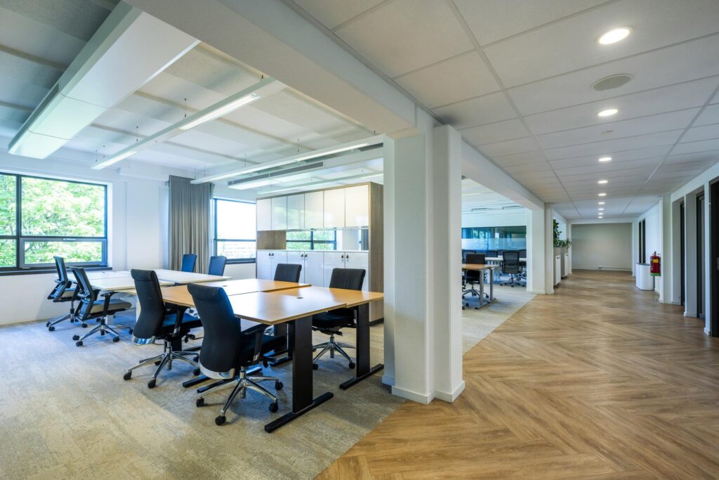 Modern open-plan office space on Mr. Treublaan with large windows, desks, and ergonomic chairs.